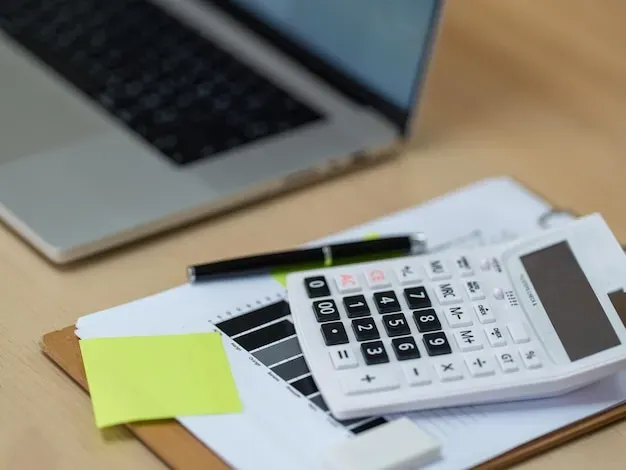 Bureau épuré bleu et or, carnet de budget et calculatrice